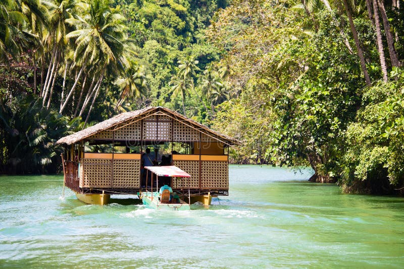 Exotic cruise boat with tourists on a jungle river. Island Bohol, Philippines. stock photo Exotic cruise boat with tourists on a jungle river. Island Bohol, Philippines. stock photo
