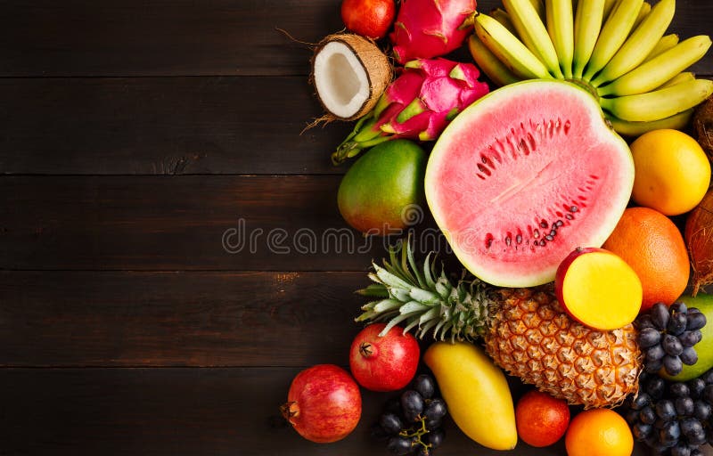 Exotisch fruit op een houten achtergrond met exemplaarruimte stock foto Exotisch fruit op een houten achtergrond met exemplaarruimte stock foto