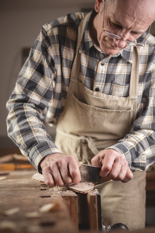 Mature carpenter scraping down a piece of wood stock photos Mature carpenter scraping down a piece of wood stock photos