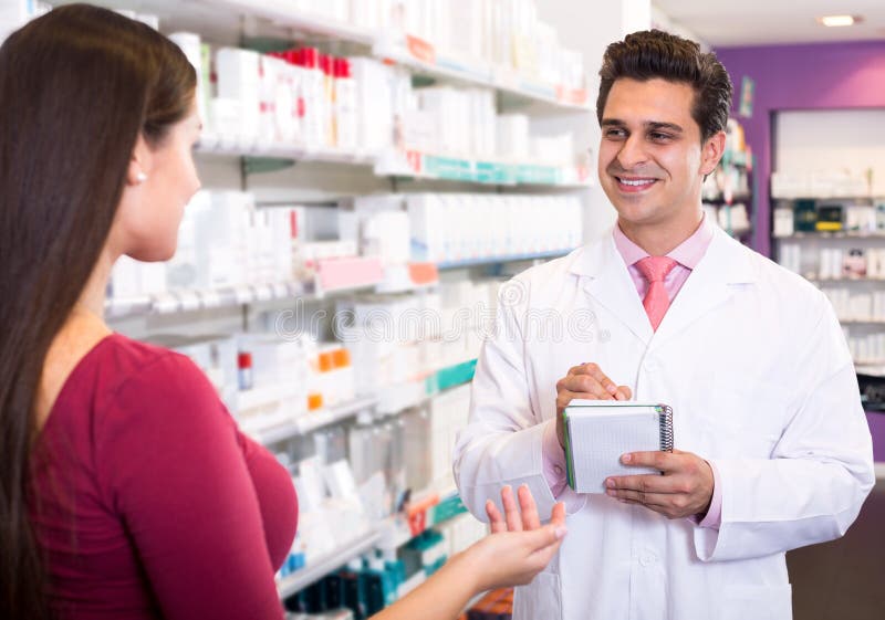 Experienced pharmacist counseling female customer stock image Experienced pharmacist counseling female customer stock image