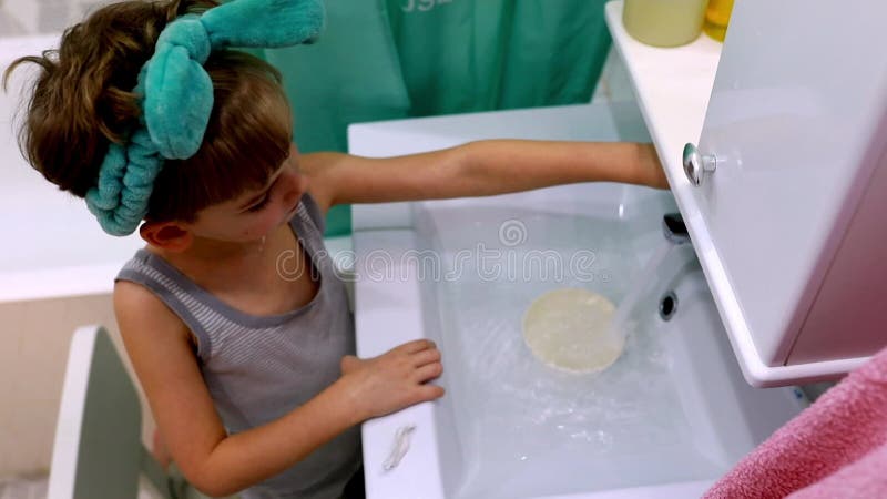 Experimentos infantiles con agua y objetos en una actividad lúdica en casa durante la tarde metrajes