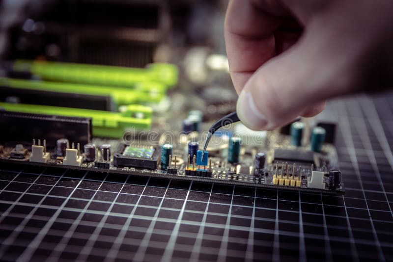 Experte setzt elektrischen Pullover auf Motherboardkontakte mit schwarzen Miniaturzangen stockfotos Experte setzt elektrischen Pullover auf Motherboardkontakte mit schwarzen Miniaturzangen stockfotos