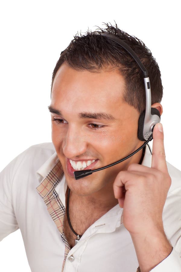 Friendly male receptionist or call centre operator listening carefully to a call on his headset as he deals with support and public relations for the company. Friendly male receptionist or call centre operator listening carefully to a call on his headset as he deals with support and public relations for the company