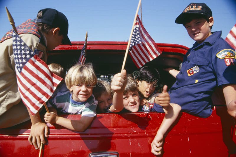 Exploradores de Cub que agitan indicadores americanos imagenes de archivo Exploradores de Cub que agitan indicadores americanos imagenes de archivo