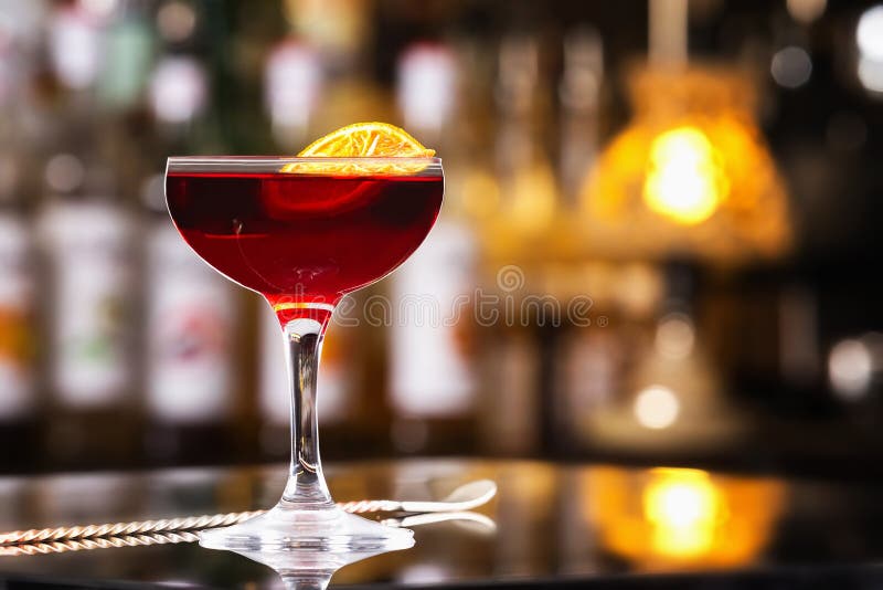 Exponeringsglas av den körsbärsröda färgalkoholcoctailen dekorerade med orange sli royaltyfri fotografi Exponeringsglas av den körsbärsröda färgalkoholcoctailen dekorerade med orange sli royaltyfri fotografi