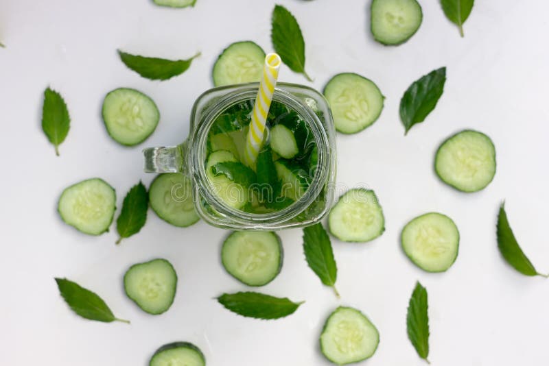 Exponeringsglas av den läckra uppfriskande sommardrinken - coctail av skivor gurka, is, mintkaramell, sugrör, bästa sikt, closeup royaltyfri foto Exponeringsglas av den läckra uppfriskande sommardrinken - coctail av skivor gurka, is, mintkaramell, sugrör, bästa sikt, closeup royaltyfri foto