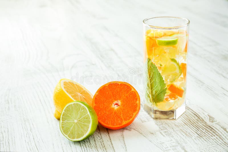 Exponeringsglas av den nya och sunda sommardrinken med citron-, limefrukt- och tangerinskivor, mintkaramellsidor och krossad is p royaltyfria foton Exponeringsglas av den nya och sunda sommardrinken med citron-, limefrukt- och tangerinskivor, mintkaramellsidor och krossad is p royaltyfria foton