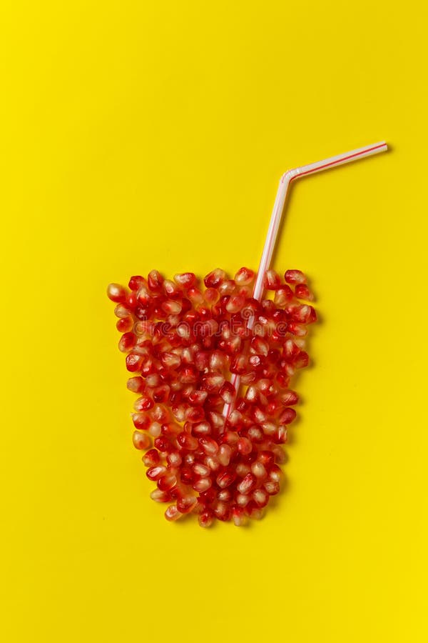 Exponeringsglas av fruktsaft som göras av granatäpplefrö och ett sugrör arkivfoto Exponeringsglas av fruktsaft som göras av granatäpplefrö och ett sugrör arkivfoto