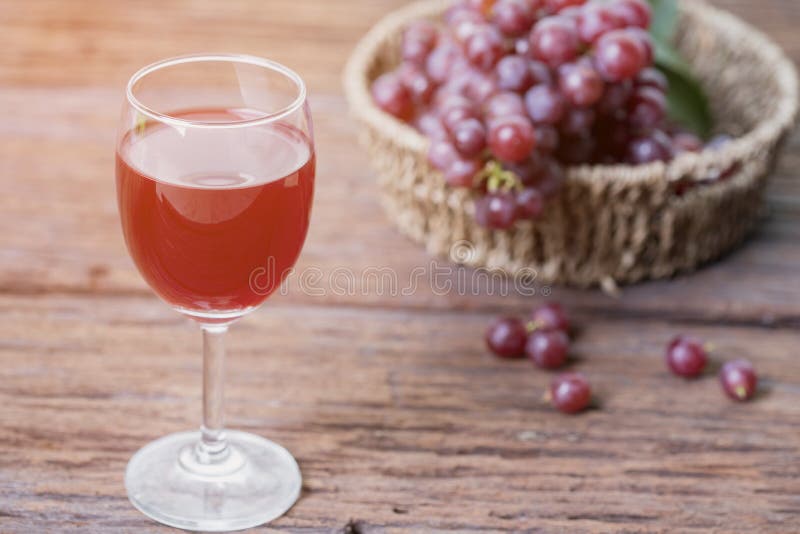 Exponeringsglas av vin eller druvafruktsaft och frukt på trätabellen arkivfoto Exponeringsglas av vin eller druvafruktsaft och frukt på trätabellen arkivfoto