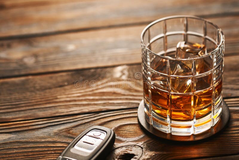 Exponeringsglas av whisky- eller alkoholdrinken med tangent för iskuber och bil Drink- och drevbegrepp arkivbilder Exponeringsglas av whisky- eller alkoholdrinken med tangent för iskuber och bil Drink- och drevbegrepp arkivbilder