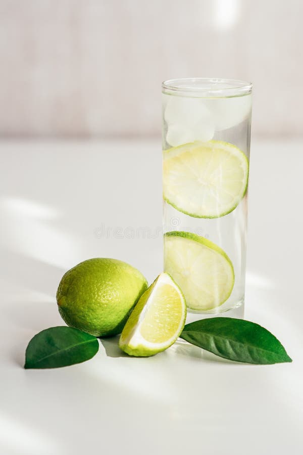 Exponeringsglas med vatten-, is- och limefruktskivor arkivbilder Exponeringsglas med vatten-, is- och limefruktskivor arkivbilder