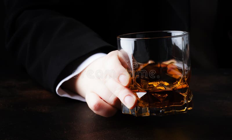Exponeringsglas med whisky i handen, mörk bakgrund, selektiv fokus arkivbilder Exponeringsglas med whisky i handen, mörk bakgrund, selektiv fokus arkivbilder
