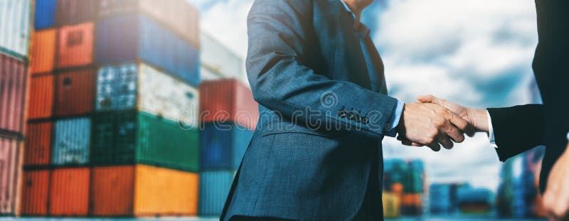 Export and import business. businessmen handshake at industrial container terminal. maritime transport and logistics