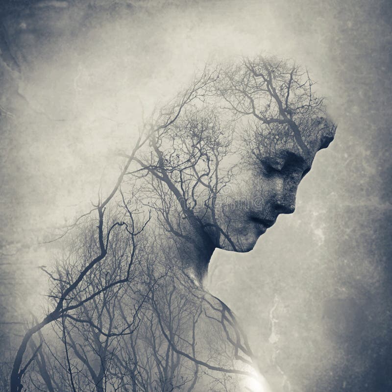 Exposición doble de un ángel del cementerio con las ramas de árbol del invierno que cubren su cara y cuerpo imagenes de archivo Exposición doble de un ángel del cementerio con las ramas de árbol del invierno que cubren su cara y cuerpo imagenes de archivo