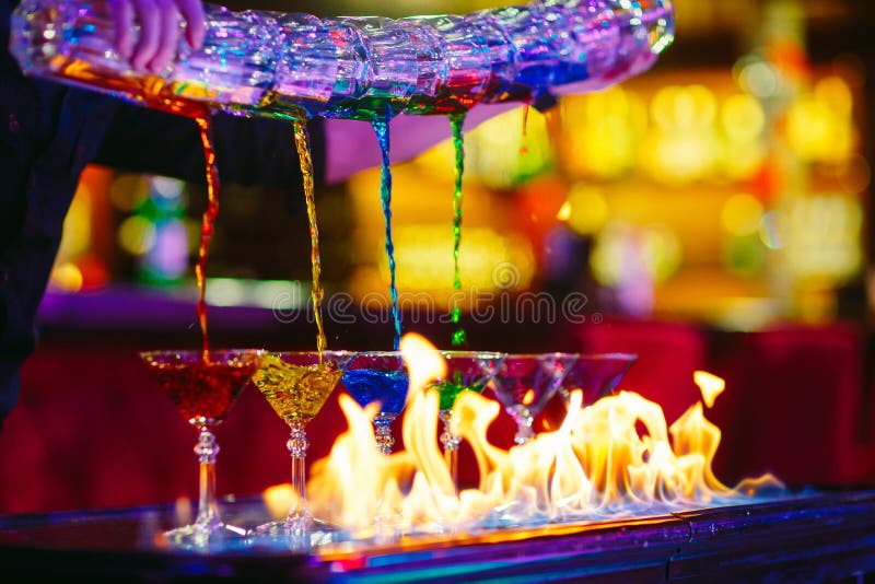 Exposition de barman Le barman verse les cocktails colorés alcooliques photos libres de droits Exposition de barman Le barman verse les cocktails colorés alcooliques photos libres de droits