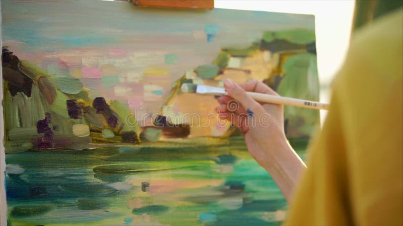Expressive close up view of girl painter at work. She painting iol picture
