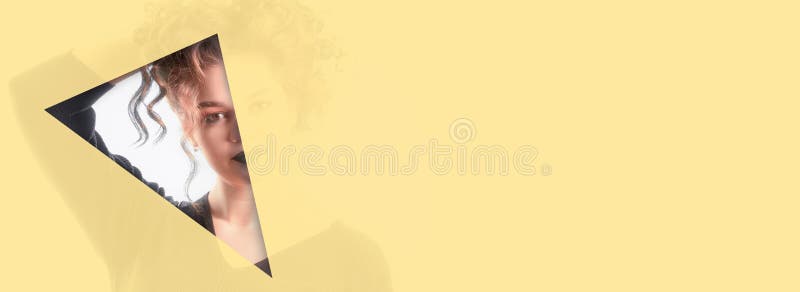 And expressive eyebrows looks into the hole of yellow translucent colored paper. royalty free stock images