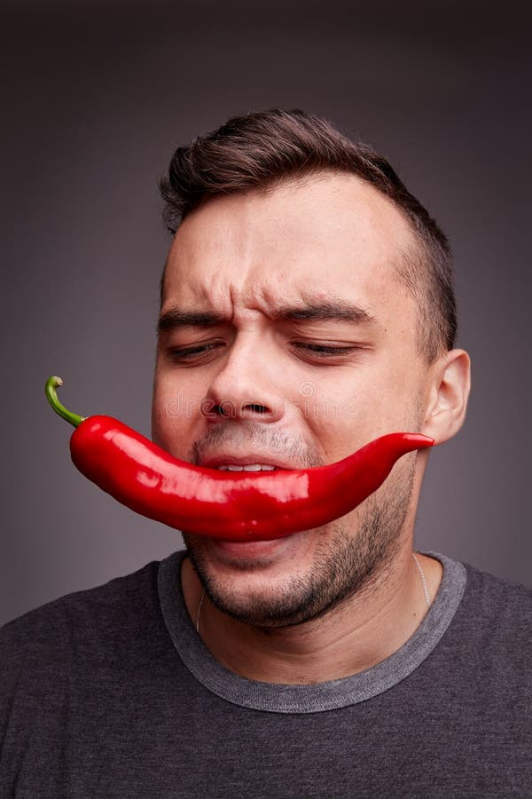 Man Holding Chili Pepper in His Teeth. Funny Guy Eating Hot, Spicy Pepper  on a Gray Background. Health Concept. Stock Image - Image of healthy,  emotion: 100230033