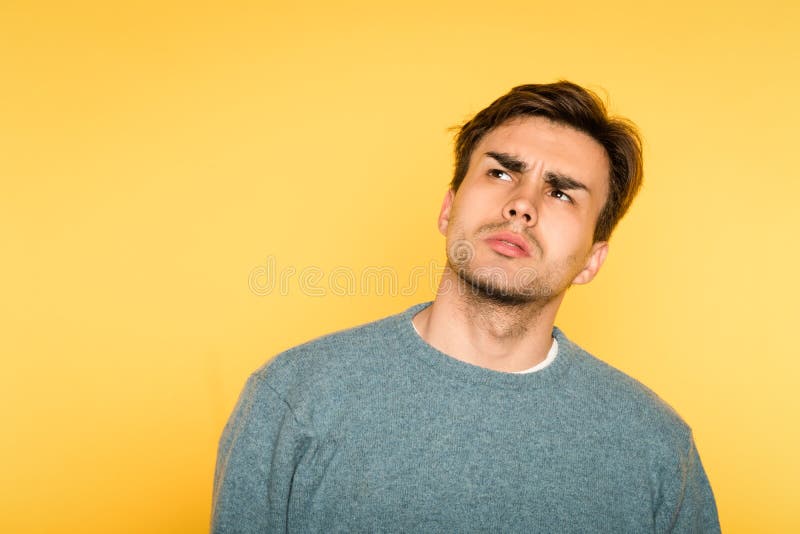 A expressão hesitante duvidoso duvidosa do homem olha acima foto de stock A expressão hesitante duvidoso duvidosa do homem olha acima foto de stock