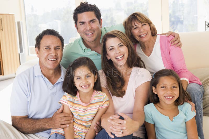 La famiglia estesa in soggiorno su divano sorridendo.