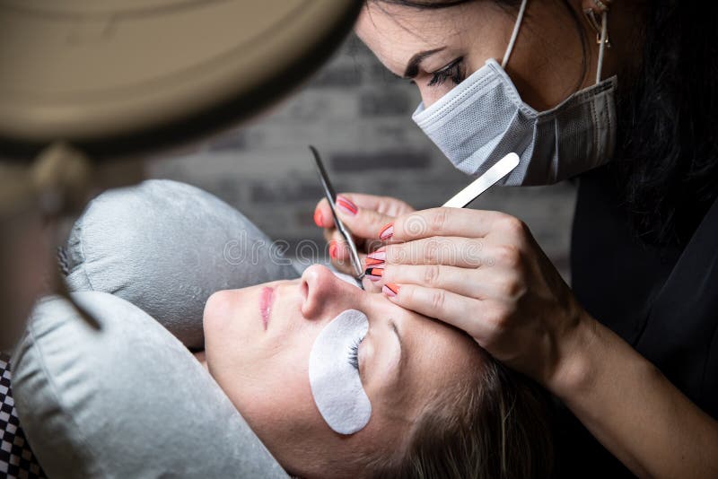 Extensions of artificial eyelash, process close up. Woman in beauty salon. Beauty and self care royalty free stock photography Extensions of artificial eyelash, process close up. Woman in beauty salon. Beauty and self care royalty free stock photography