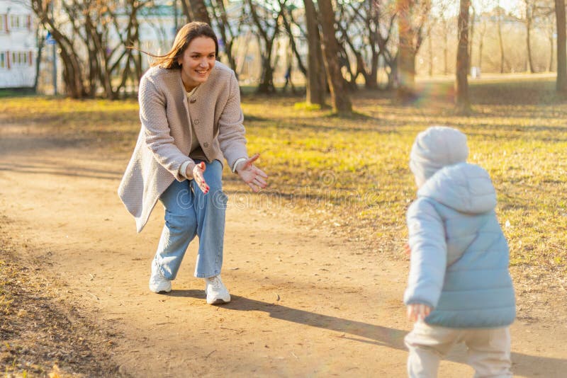 Exterior familiar. madre niña caminando en el parque. mamá jugando con su bebé al aire libre. mujer niño pequeño descansando imagen de archivo libre de regalías