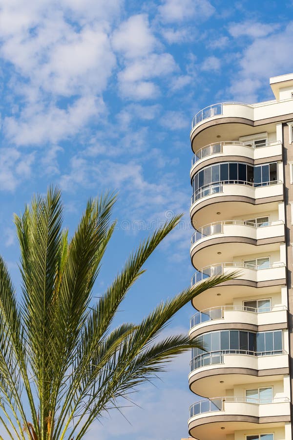 Exterior Of A Modern Apartment Building Against A Blue Sky With Clouds exterior-of-a-modern-apartment-building-against-a-blue-sky-with-clouds