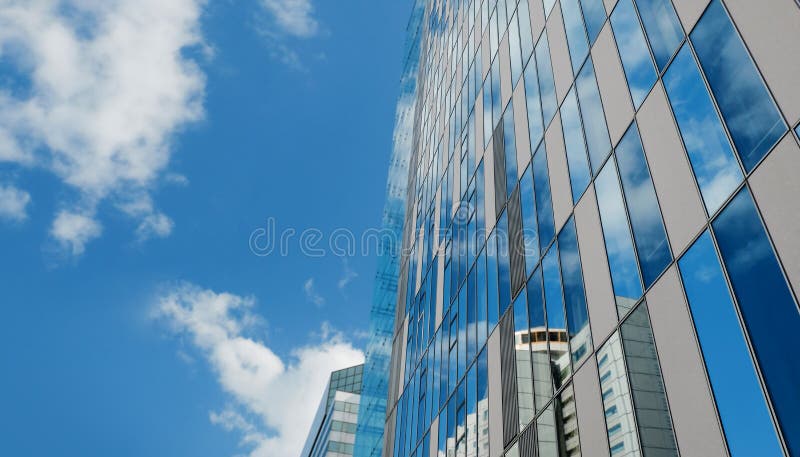 Exterior of Modern Glass Office Building in Urban City on Sunny Day. Blue Sky as background