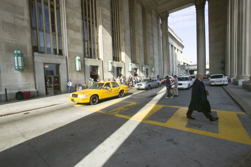 Exterior view of yellow taxi cab and walking business man in front of the 30th Street Station, a national Register of Historic Pl stock photography Exterior view of yellow taxi cab and walking business man in front of the 30th Street Station, a national Register of Historic Pl stock photography