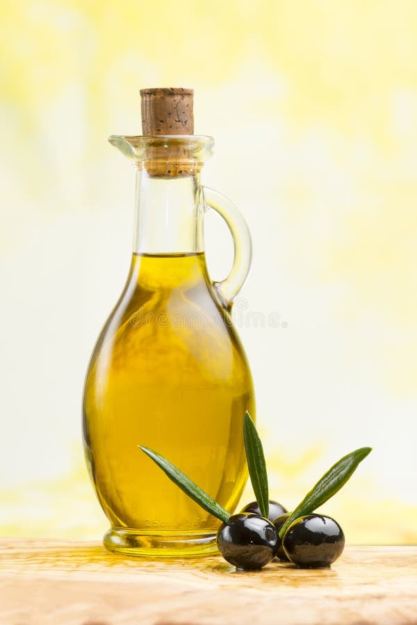 Extra Virgin Olive Oil with Black Olives on Olive Board Stock Photo