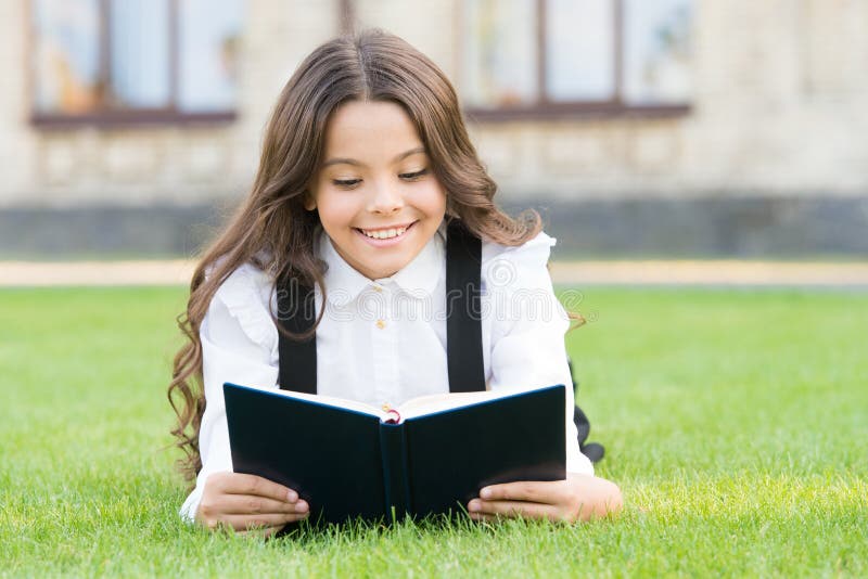 Extracurricular reading. Cute small child reading book outdoors. Adorable little girl learn reading. Schoolgirl school