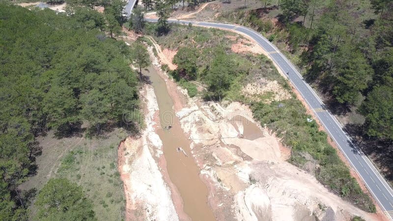 A extração aérea da areia trabalha no rio raso pela estrada