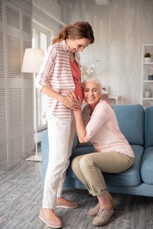 Extrem glückliche Frau, die ihr Ohr nahe schwangerem Bauch setzt stockfotos Extrem glückliche Frau, die ihr Ohr nahe schwangerem Bauch setzt stockfotos