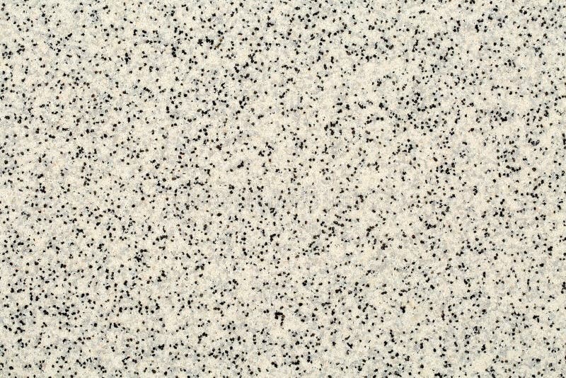 Extreme close up of decorative quartz sand epoxy floor or wall coating with different shades of grey, white and black coloured