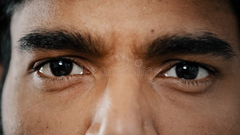 Extreme close up face of young arabian male adult model man male eyes with dark eyeballs stare looking at camera show