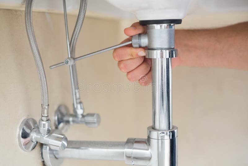 Extreme Close up of a plumber's hand and washbasin drain royalty free stock image Extreme Close up of a plumber's hand and washbasin drain royalty free stock image
