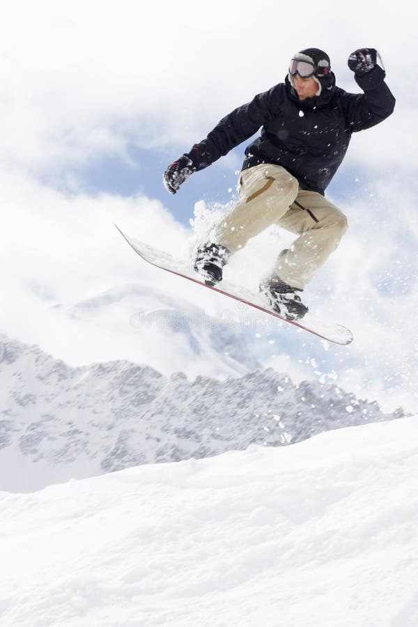 Snowboarder prendendo un salto nella neve fresca.