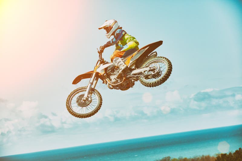 Extreme sporten, motorfiets het springen De motorrijder maakt een extreme sprong tegen de hemel Extreme sporten, motorfiets