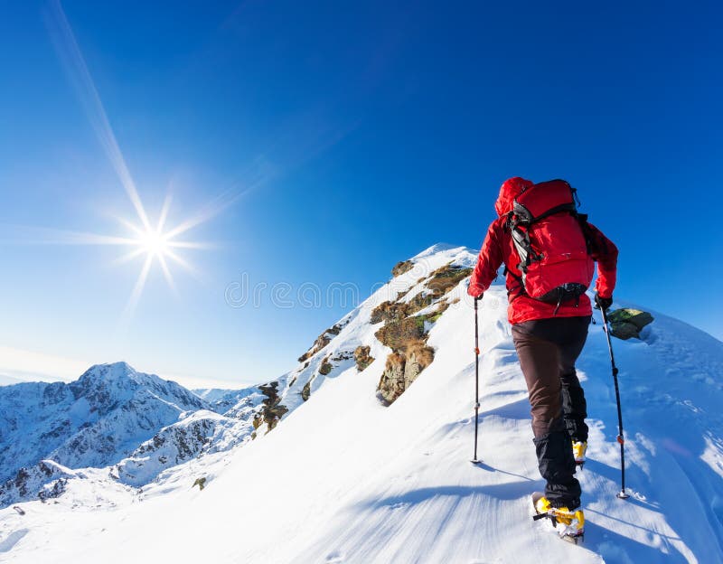 Extreme winter sports: climber at the top of a snowy peak in the