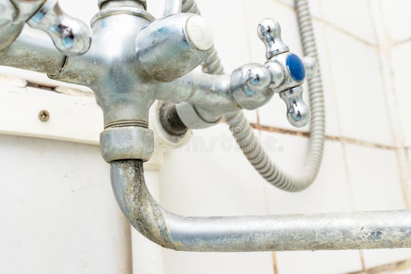 Extremely dirty water tap spout with limescale and rust close up, calcified detail of shower mixer tap need to be cleaned royalty free stock images