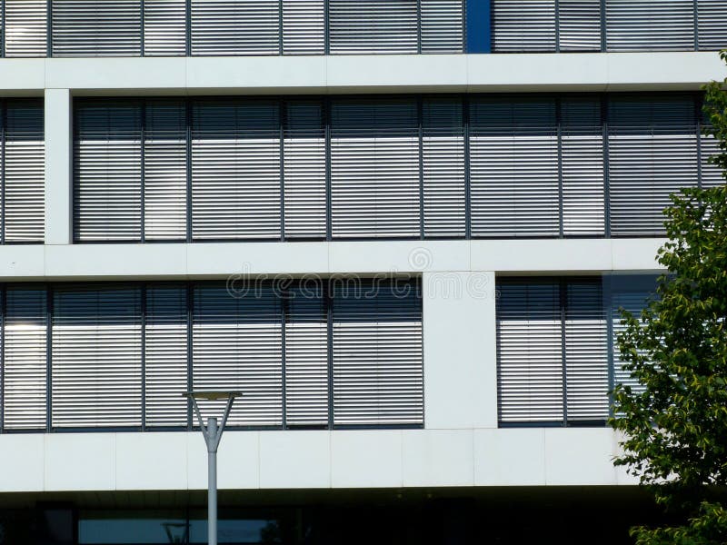 Extérieur de construction moderne dans la vue frontale avec les abat-jour horizontaux images stock Extérieur de construction moderne dans la vue frontale avec les abat-jour horizontaux images stock