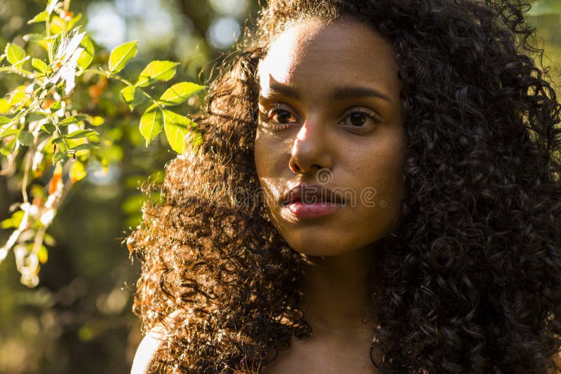 Extérieur de portrait d'une belle jeune femme afro-américaine au su image libre de droits Extérieur de portrait d'une belle jeune femme afro-américaine au su image libre de droits
