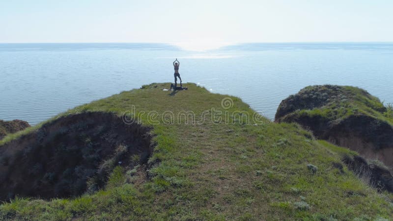 Extérieur de yoga, homme fort de yogi et femme flexible faisant étirant l'exercice d'acroyoga sur l'herbe en nature près de la me