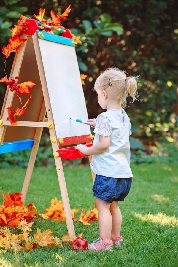 Extérieur debout d'enfant en bas âge d'enfant de fille caucasienne blanche d'enfant dans le dessin de parc d'automne d'été sur le photographie stock libre de droits Extérieur debout d'enfant en bas âge d'enfant de fille caucasienne blanche d'enfant dans le dessin de parc d'automne d'été sur le photographie stock libre de droits
