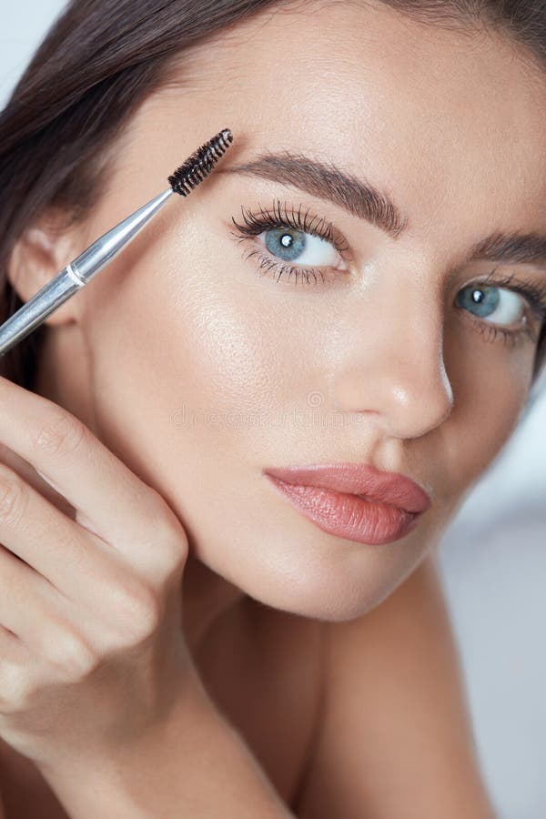 Eyebrow Makeup. Woman Brushing Brows With Brush. Beautiful Girl With Blue Eyes And Perfect Skin