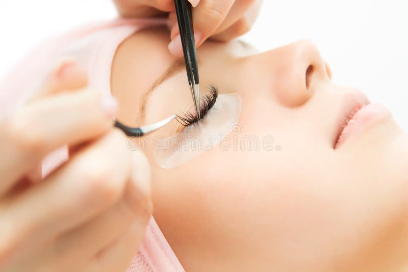 Eyelash Extension Procedure. Woman Eye with Long Eyelashes.