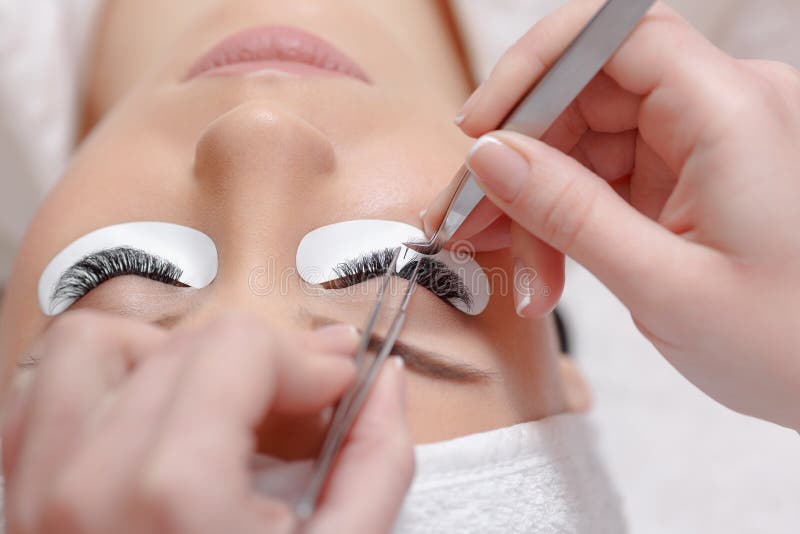 Eyelash Extension Procedure. Woman Eye with Long Eyelashes