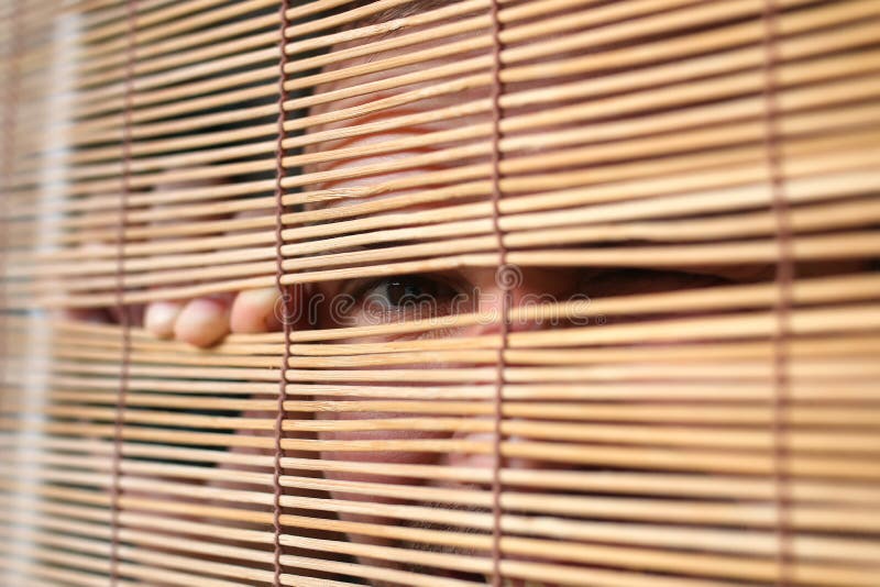 Eyes looking through the blinds stock image Eyes looking through the blinds stock image