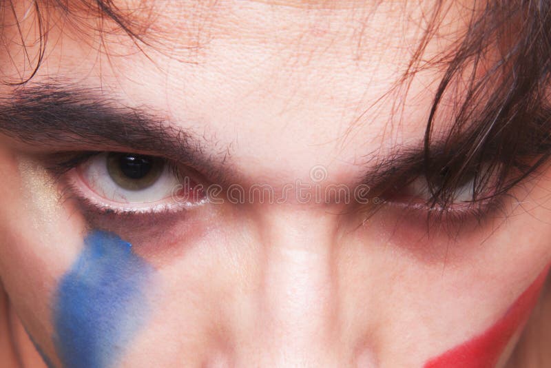 Eyes of man with the red and blue paint