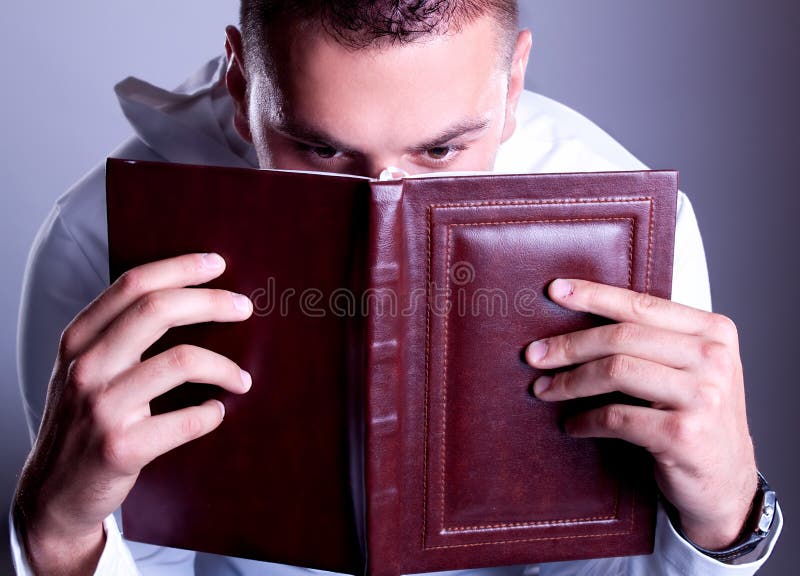 Eyes of surprised man above brown book